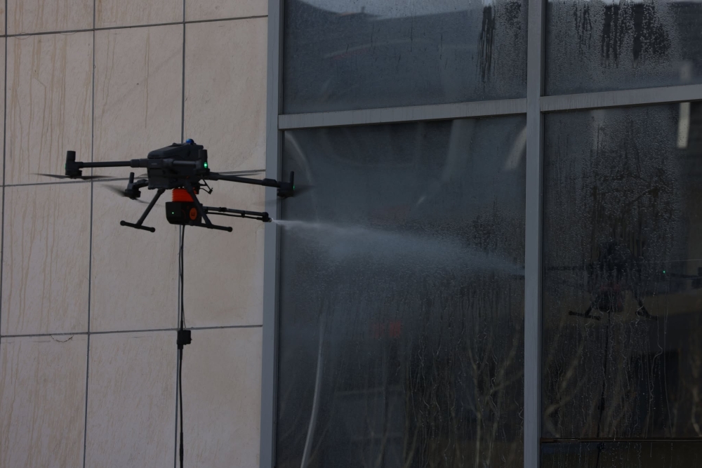 Барилгын гадна фасад, гэрлэн дохиог тусгай төхөөрөмж ашиглан угааж байна